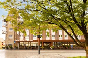 a building with a tree in front of it at Dormio Wijnhotel Valkenburg in Valkenburg