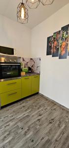 eine Küche mit gelben Schränken und Holzböden in der Unterkunft Apartment Žuna in Senj