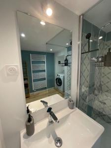 Superbe appartement lumineux في غويريت: حمام مع حوض ومرآة كبيرة