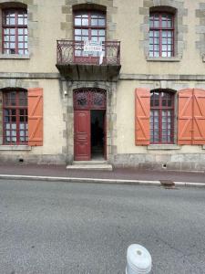 um edifício com uma porta vermelha e uma varanda em Superbe appartement lumineux em Guéret