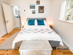 1 dormitorio con 1 cama con almohadas azules en Little Willow Bank - 1 bed luxury apartment between Salisbury and The New Forest, en Salisbury