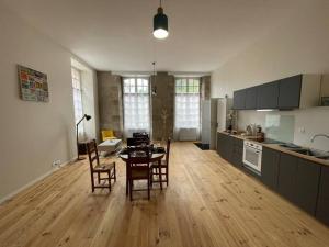 cocina y comedor con mesa y sillas en Superbe appartement lumineux en Guéret
