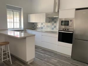 a kitchen with white cabinets and a stove top oven at Apartamento Cañebolo in La Puebla de los Infantes