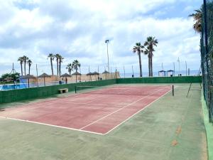 una pista de tenis con palmeras al fondo en Casa Bahia By Solymar Holiday, en Algarrobo Costa
