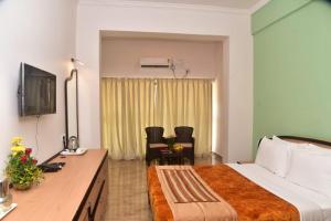a hotel room with a bed and a desk at Calangute Residency in Calangute