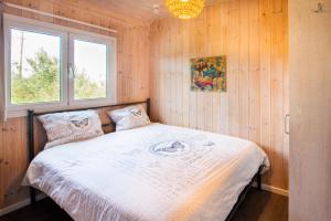 1 dormitorio con 1 cama en una pared de madera en Hakuna Matata Holidays 'Agalia' with pool in Greek Olive Grove en Methoni
