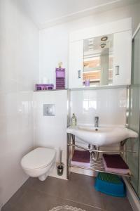 een witte badkamer met een toilet en een wastafel bij Hakuna Matata Holidays 'Agalia' with pool in Greek Olive Grove in Methoni