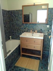 een badkamer met een wastafel, een bad en een spiegel bij T3 Duplex 65 m2 6 lits 2 SDB terrasse clim garage in Valescure