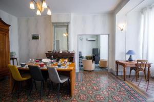 a dining room with a table and chairs and a living room at Maison Eglantine YourHostHelper Classé 4* in Narbonne