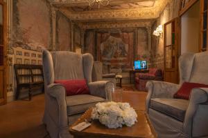 un soggiorno con sedie e tavolo con fiori di Hotel Palazzo San Niccolò & Spa a Radda in Chianti