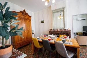 a dining room with a wooden table and chairs at Maison Eglantine YourHostHelper Classé 4* in Narbonne