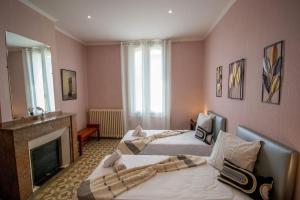 a bedroom with three beds and a fireplace and a mirror at Maison Eglantine YourHostHelper Classé 4* in Narbonne