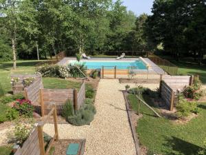 een tuin met een zwembad in een tuin bij Gîte Val de Louyre et Caudeau, 3 pièces, 4 personnes - FR-1-616-282 in Saint-Alvère