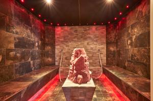 a stone statue in a room with red lights at Kristall- & Vitalhotel Bergknappenhof in Bodenmais +54 photos
