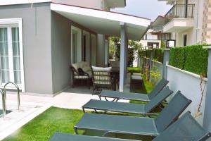 a patio with chairs and tables on a house at Dalyan Central 4 Bedroom Ensuite Private Villa with Swimming Pool in Dalyan