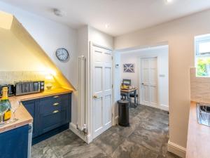 a kitchen with blue cabinets and a table at Pass the Keys Stylish newly renovated Victorian 2 bedroom house in Shrewsbury