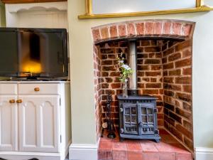 a brick fireplace with a stove in a room at Pass the Keys Stylish newly renovated Victorian 2 bedroom house in Shrewsbury
