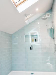 y baño con azulejos azules y ducha. en Little Willow Bank - 1 bed luxury apartment between Salisbury and The New Forest, en Salisbury