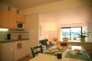 a kitchen and living room with a table and a kitchen and a dining room at Lagrange Vacances Résidence du Golf in Saint-Cyprien