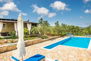 a villa with a swimming pool and a house at Hakuna Matata Holidays Agalia with airco & pool in Greek Olive Grove in Methoni