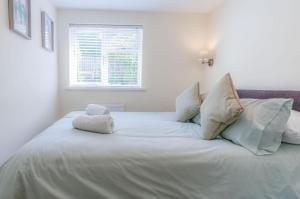 Myrtle - 1 Bedroom Apartment - Saundersfoot في ساندرزفوت: سرير أبيض كبير في غرفة نوم مع نافذة