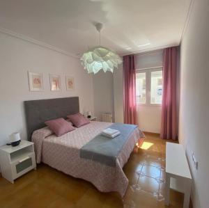 a bedroom with a bed and a chandelier at Puerta del Sol - Plasencia in Plasencia