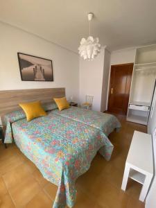 a bedroom with a bed and a chandelier at Puerta del Sol - Plasencia in Plasencia