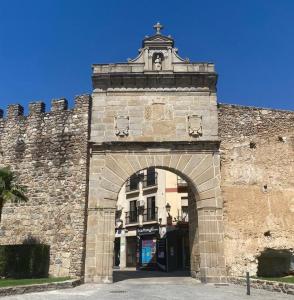 uma entrada para um edifício de tijolos com uma arcada em Puerta del Sol - Plasencia em Plasencia
