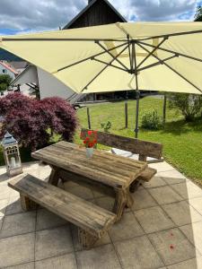 ein Picknicktisch und ein Regenschirm mit Blumen drauf in der Unterkunft Home Sweet Home by Stay Swiss in Courtedoux