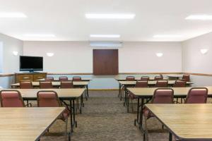 a classroom with tables and chairs and a flat screen tv at Baymont by Wyndham Piqua in Piqua