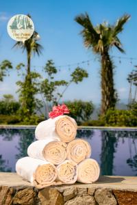 een stapel handdoeken op een tafel naast een zwembad bij TVpalm Ecolodge in Ha Giang