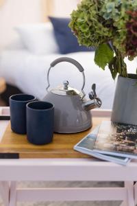 a tea kettle and two cups on a table at Goldfield Glamping in Clydesdale