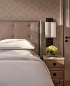 a bedroom with a white bed and a nightstand with flowers at Great Scotland Yard Hotel, part of Hyatt in London