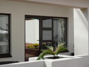 ein Haus mit einer Topfpflanze vor einem Fenster in der Unterkunft Isle La Breeze Guest House in Witbank