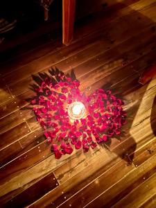 a heart shaped arrangement of red flowers on a wooden floor at La Colonial Resort in El Nido