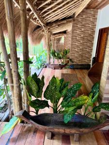 um quarto com uma banheira com plantas num piso de madeira em La Colonial Resort em El Nido