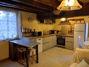 a kitchen with a table and a refrigerator at auxhirondelles in Pouilly-sous-Charlieu