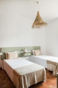 two beds sitting next to each other in a room at Cerca Velha - Country House in Albufeira