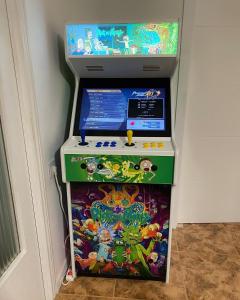 una máquina de videojuegos en una esquina de una habitación en Casa con piscina, Villa Alarilla, en Fuentidueña de Tajo