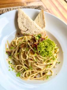 a plate of pasta with two slices of bread at La Colonial Resort in El Nido
