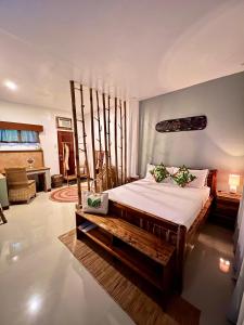 a bedroom with a large bed with a wooden frame at La Colonial Resort in El Nido
