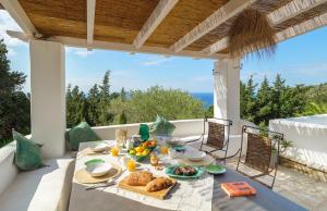 una mesa con comida y vistas al océano en Villa Pelagia, en Arvanitakaíïka