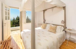 1 dormitorio con cama con dosel y ventana en Villa Pelagia, en Arvanitakaíïka