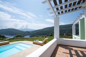 a villa with a swimming pool and a view of the mountains at Petra Mare Village in Kerveli