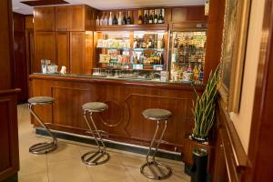 eine Bar mit drei Hockern in einem Zimmer mit Alkohol in der Unterkunft Hotel Miramare in Marina di Varcaturo