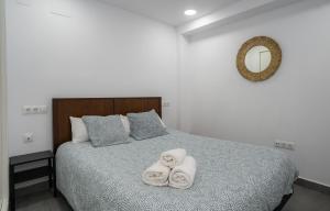 a bedroom with a bed with towels on it at APARTAMENTOS EL CARMEN Carihuela PLAYA in Torremolinos