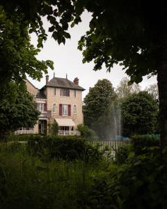 une maison avec une fontaine en face d'un jardin dans l'établissement Le Pavillon de St Agnan, à Hautefort