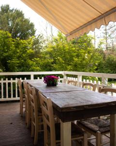 a wooden table and chairs on a deck at Le Pavillon de St Agnan in Hautefort