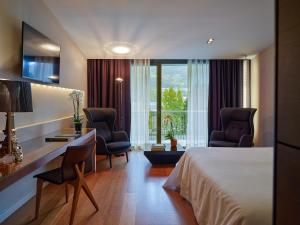 a hotel room with a bed and two chairs at Andorra Park Hotel in Andorra la Vella