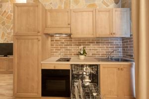 a kitchen with wooden cabinets and a dishwasher at Fattoria Maremmana in Marina di Grosseto